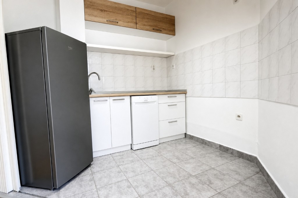 Kuhinja sa frižiderom, sudoperom i posuđem
